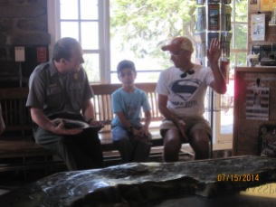 Owen sits down with a park ranger and they go over his activity book.